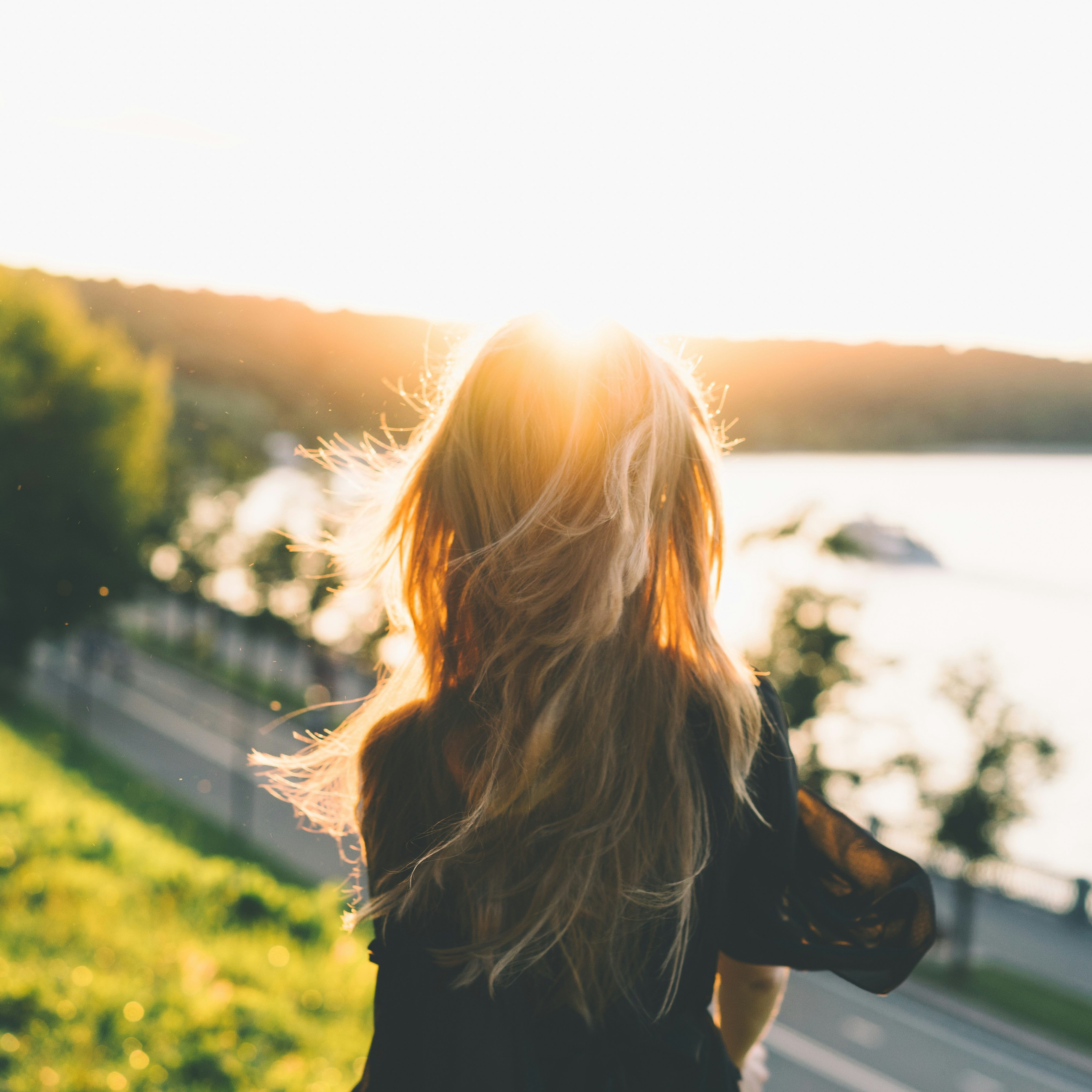 A serene image of a woman looking out at a tranquil lake
